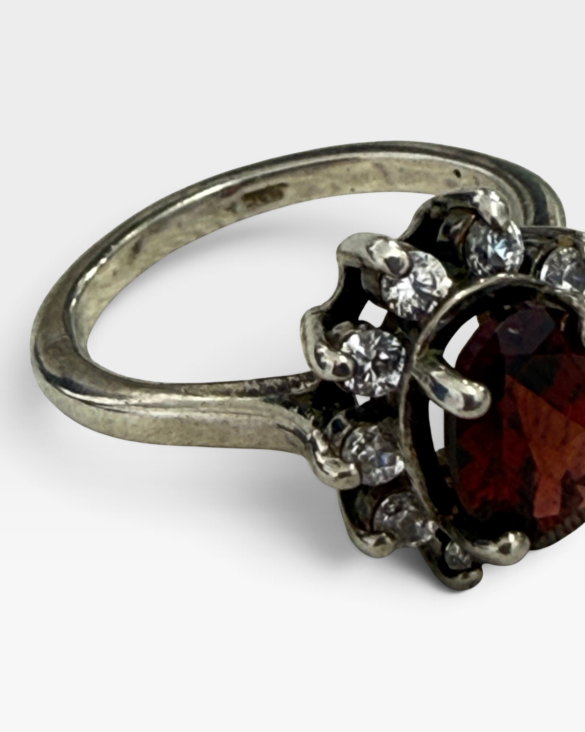 Cavallaro Creations vintage-inspired oval garnet halo ring with sparkling white stones set in a polished silver band.