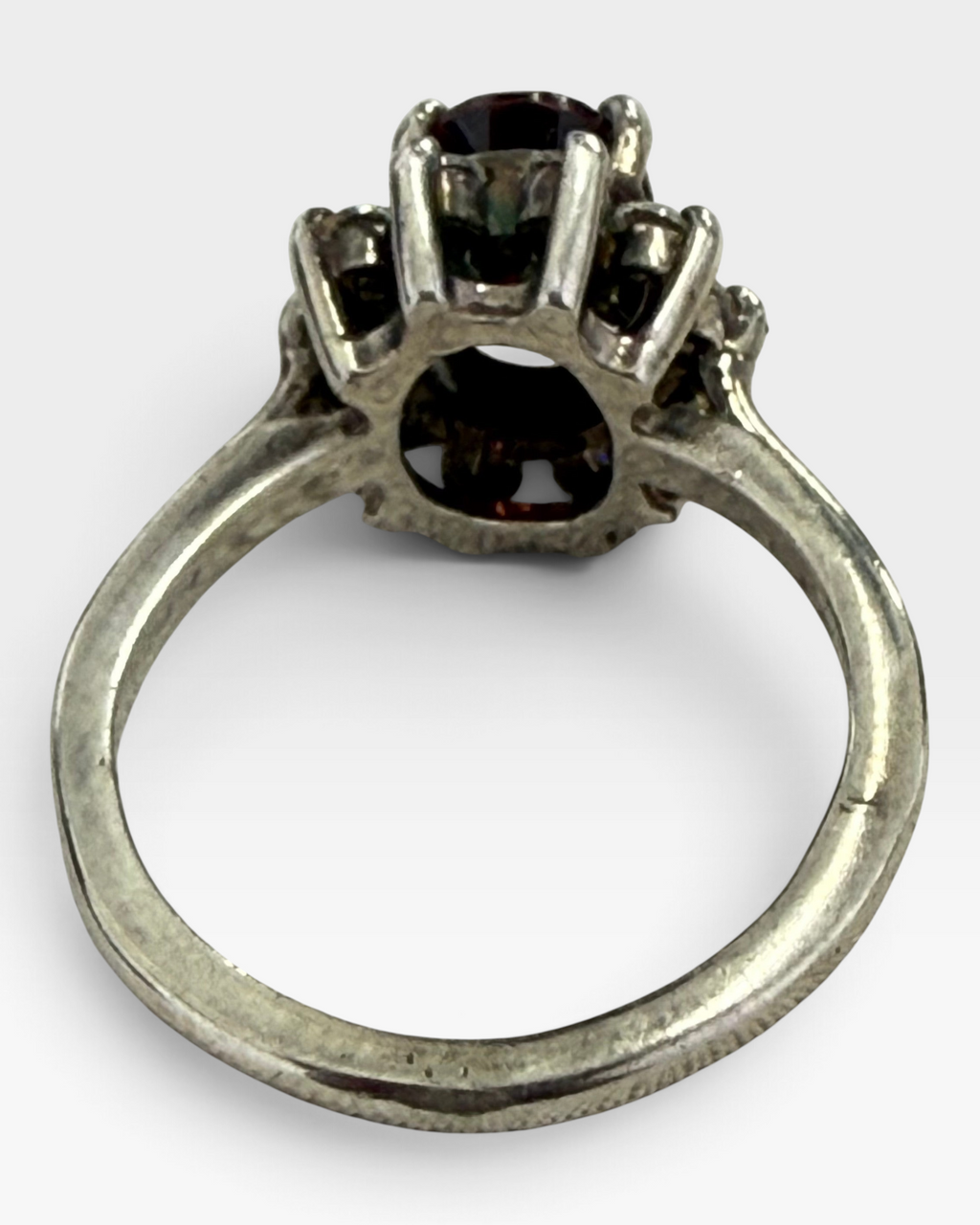 Cavallaro Creations vintage-inspired oval garnet halo ring with sparkling white stones set in a polished silver band.