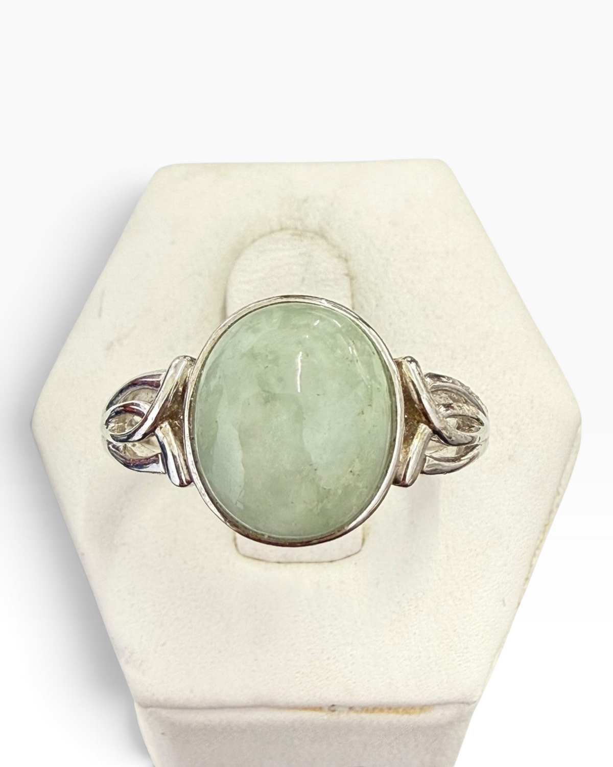 Cavallaro Creations sterling silver ring with an oval pale green cabochon stone and intricate scrollwork shoulders.