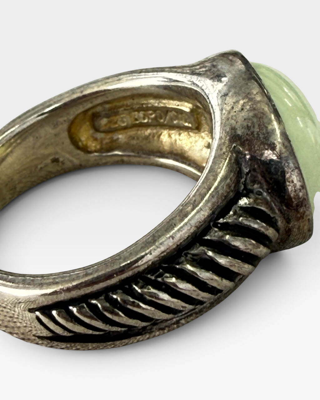 Cavallaro Creations sterling silver ring with a pale green cabochon stone and textured ribbed band detail.