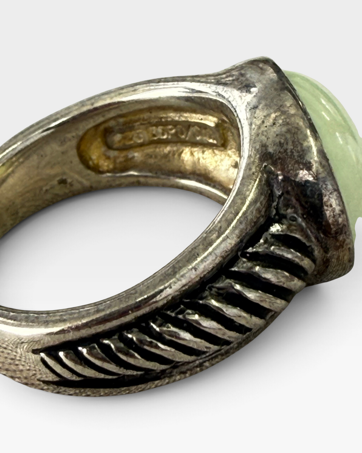 Cavallaro Creations sterling silver ring with a pale green cabochon stone and textured ribbed band detail.