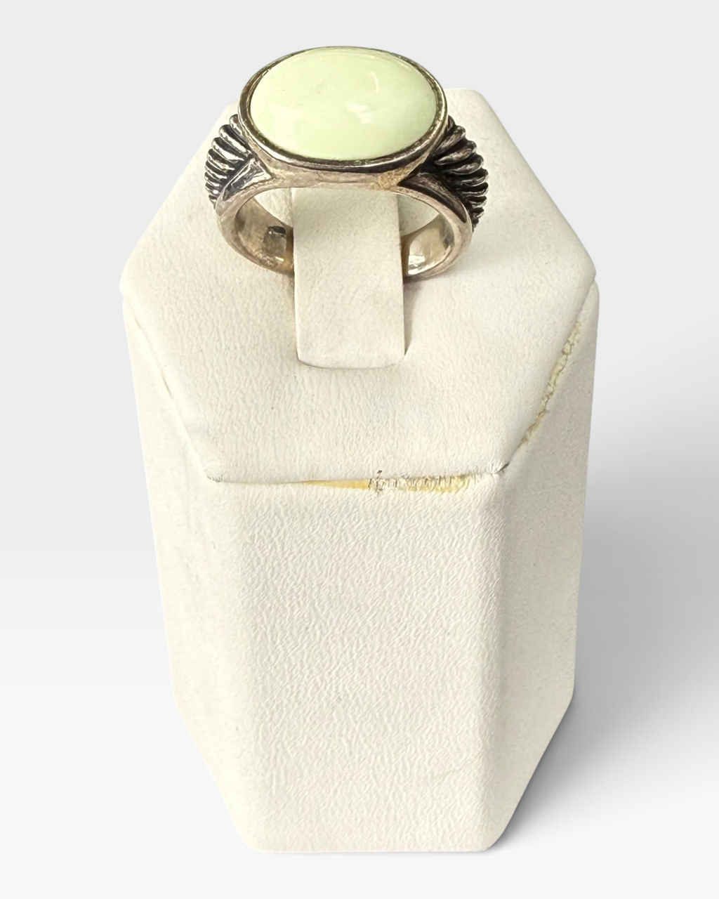 Cavallaro Creations sterling silver ring with a pale green oval cabochon stone and textured ribbed side detailing.