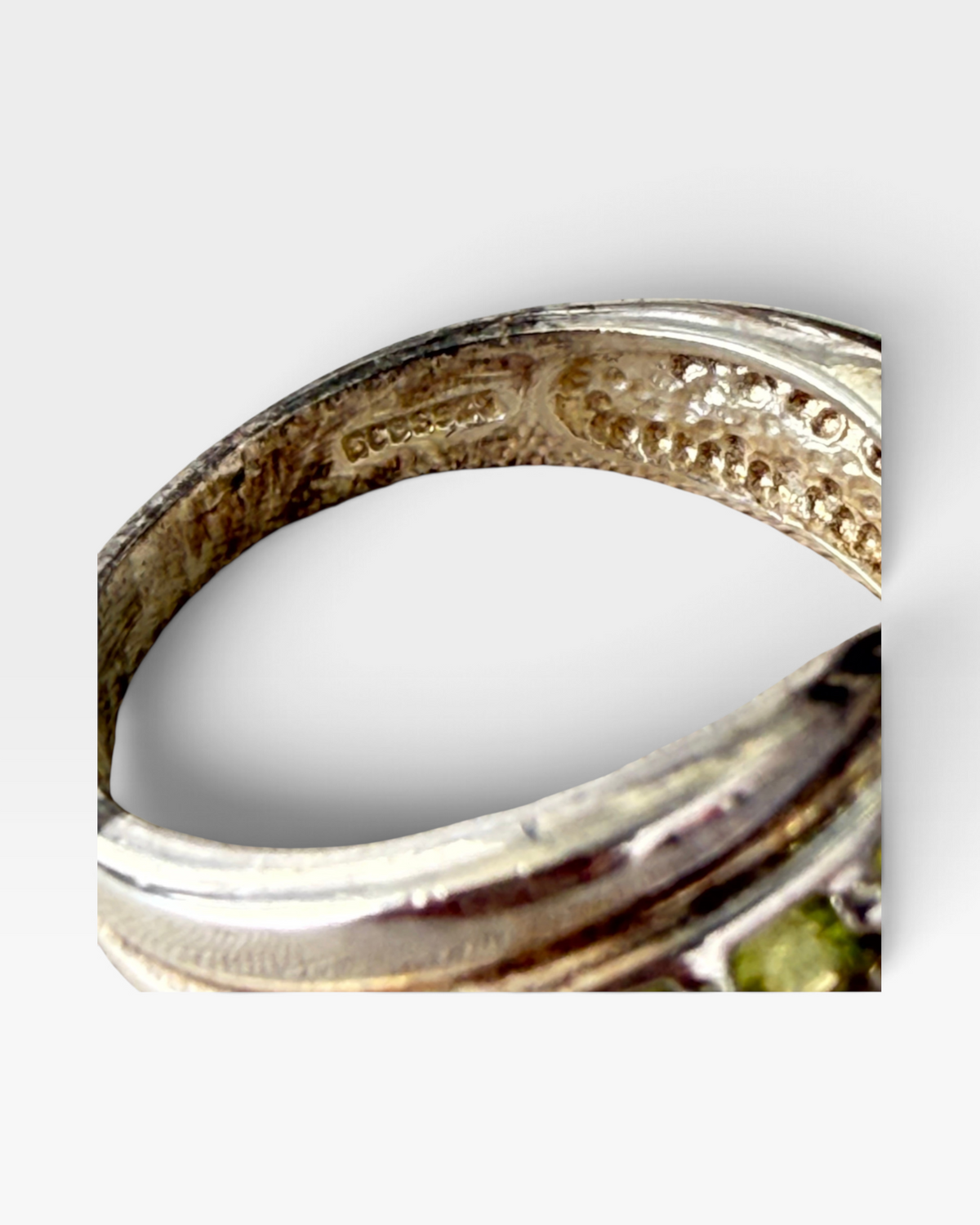 Cavallaro Creations 925 sterling silver ring with a bypass design and peridot gemstones, showing interior hallmark.