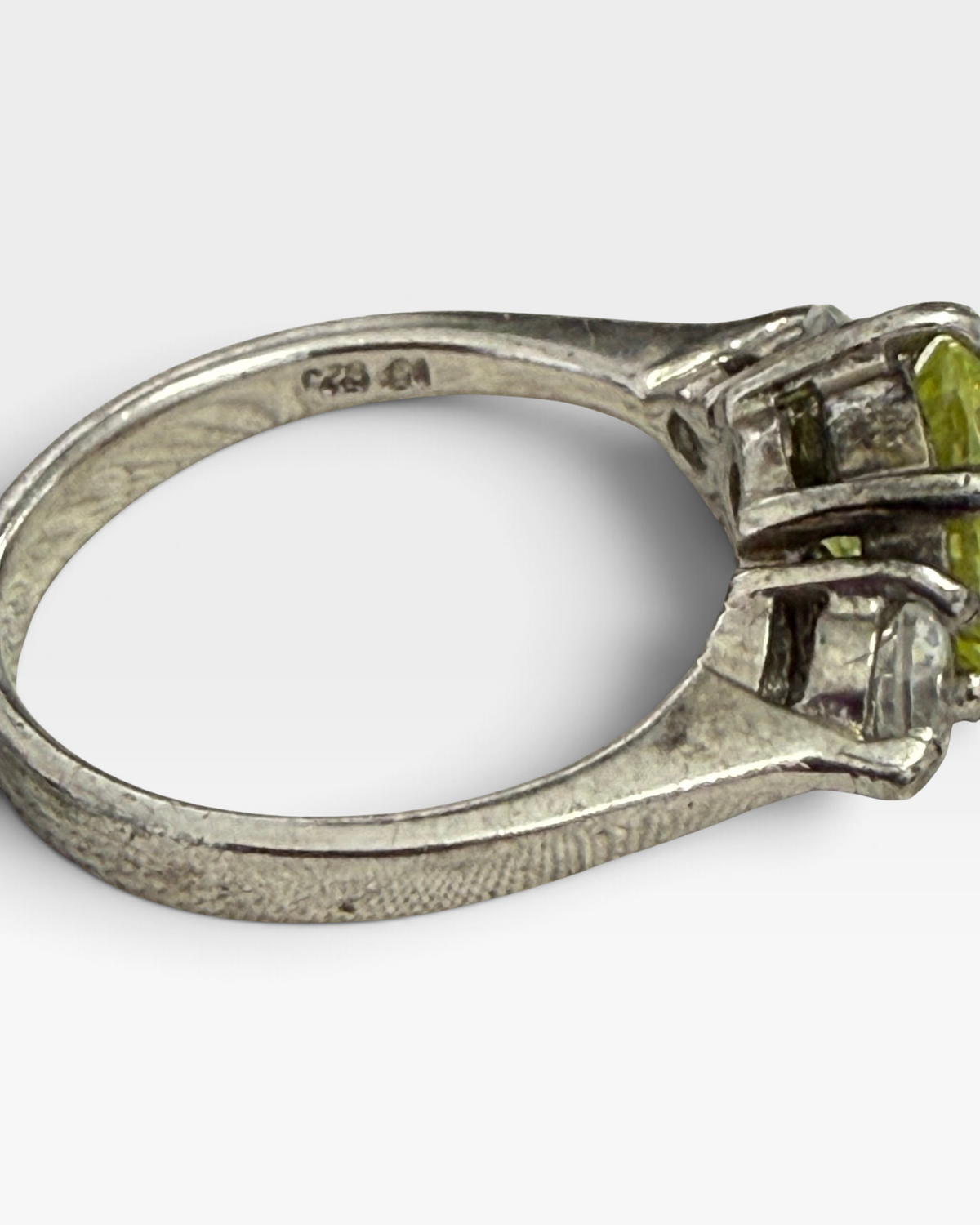 Cavallaro Creations three-stone ring with a yellow center stone and clear side stones on a polished silver-tone band.